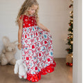Girl wearing a red and white Christmas lounge gown with festive bow print and red ruffle trim.