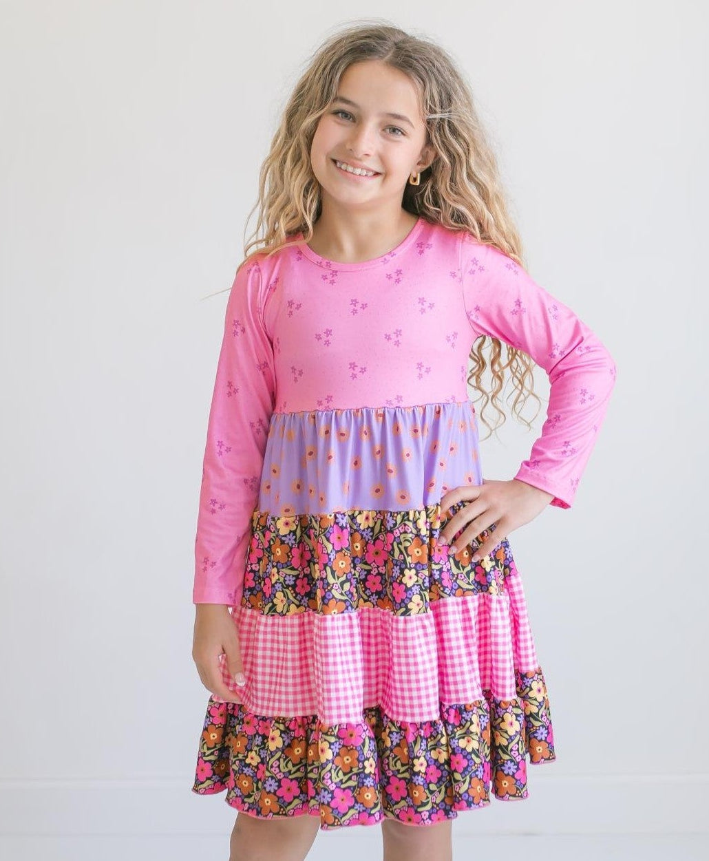 Front view of girls' pink floral twirl dress with long sleeves and ruffled skirt.