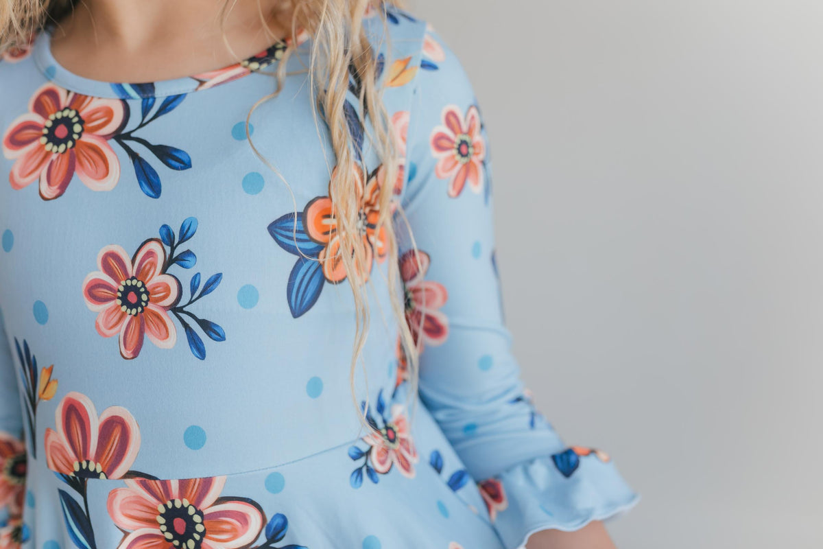 Close-up of blue and pink floral print on girls' ruffle dress.