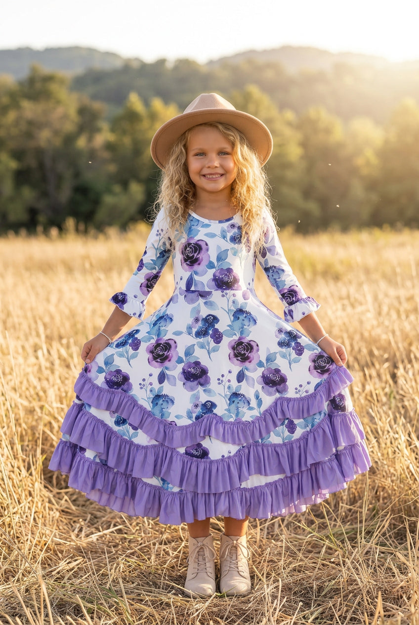 1	Girl wearing a lavender floral dress with layered purple ruffles while standing in a field.