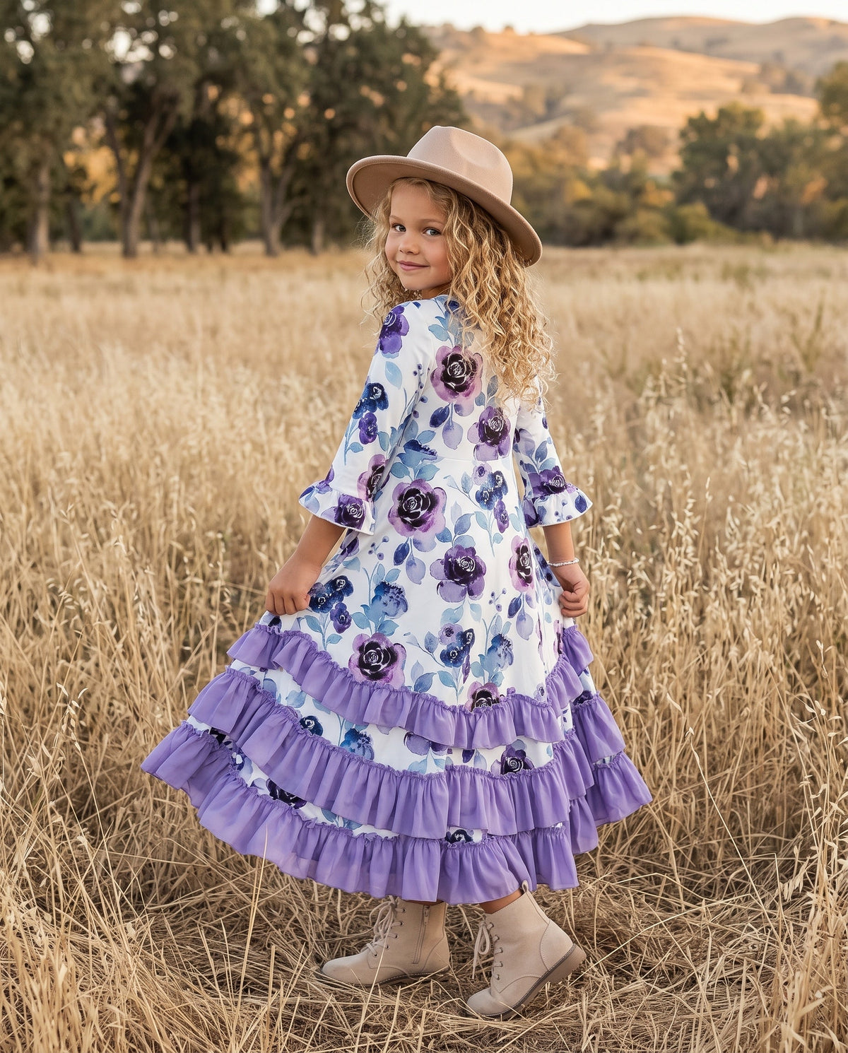 Girls' lavender floral ruffle dress modeled outdoors with a flowing layered skirt.