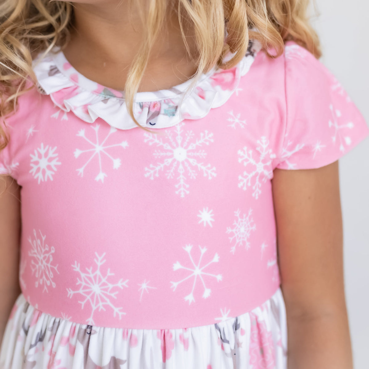 Close-up of pink ruffle details on girls' deer print Christmas nightgown.
