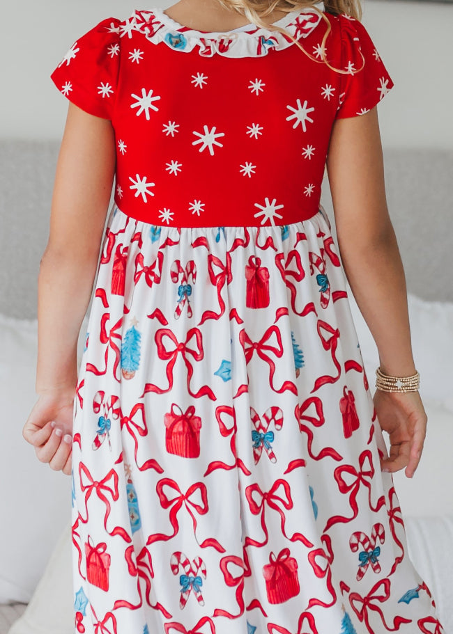 Red and white girls' Christmas lounge gown featuring a festive bow print, red bodice, and ruffle trim.