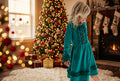 Girl wearing a solid teal green long sleeve dress with ruffle details.