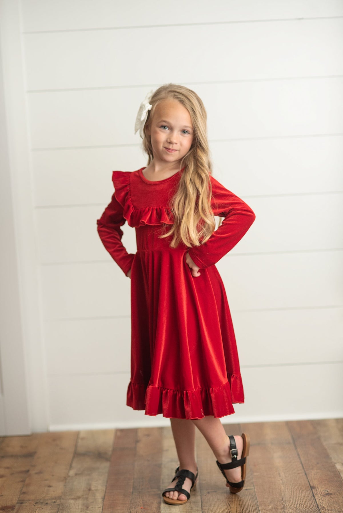 Girl modeling a red Christmas dress with long sleeves.